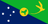 The flag of Christmas Island is divided diagonally from upper hoist side to lower fly side. The upper triangle is green with a yellow image of a Golden Bosun Bird. The lower triangle is blue with the Southern Cross constellation. A centered yellow disk displays a green map of the country.
